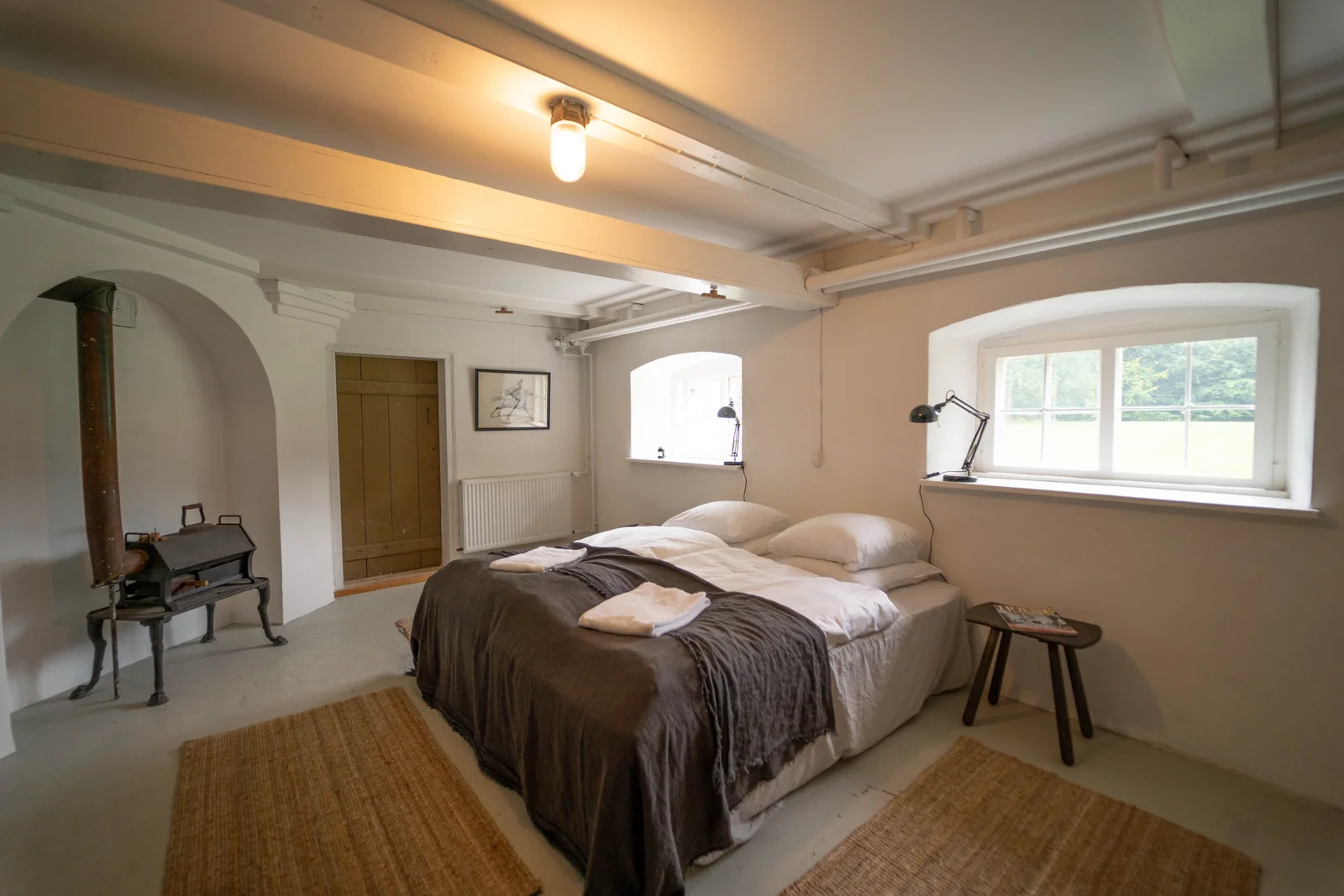 Gästezimmer im Herrenhaus von Gut Agerup mit Doppelbett, gewölbter Nische und Gartenfenster