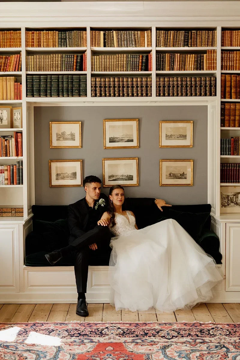 Brudepar i biblioteket på Agerup Gods foran bogsamlingen og familieportrætter