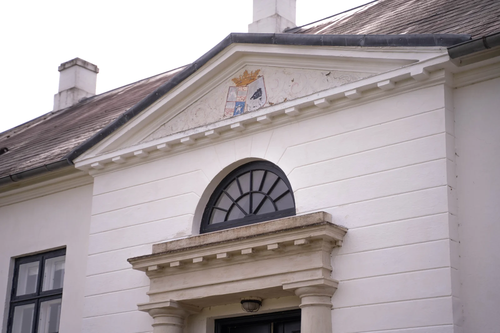Der Giebel mit Wappen und Lünettenfenster am Herrenhaus von Gut Agerup