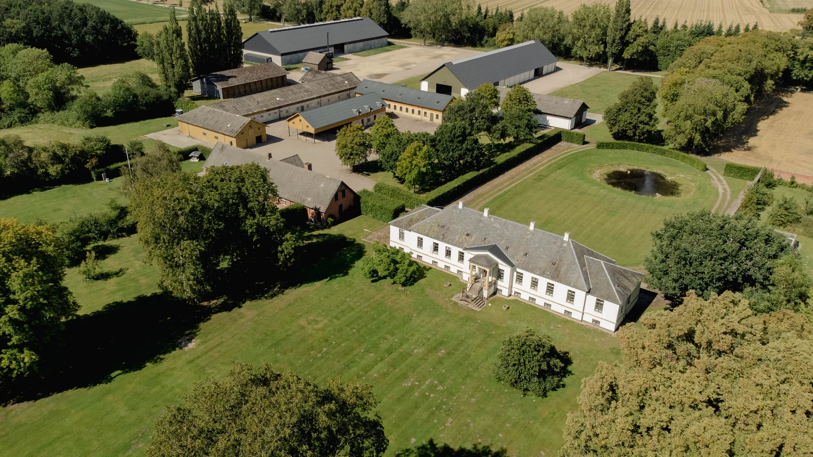 Gut Agerup aus der Luft mit Herrenhaus, Park und Teich an einem Sommertag