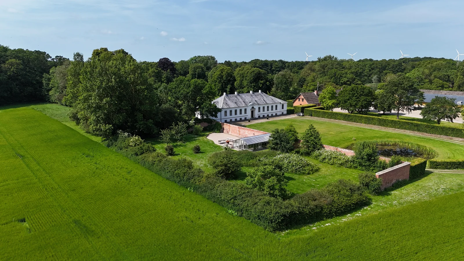 Der ummauerte Garten und das Herrenhaus von Gut Agerup aus der Luft über den Feldern