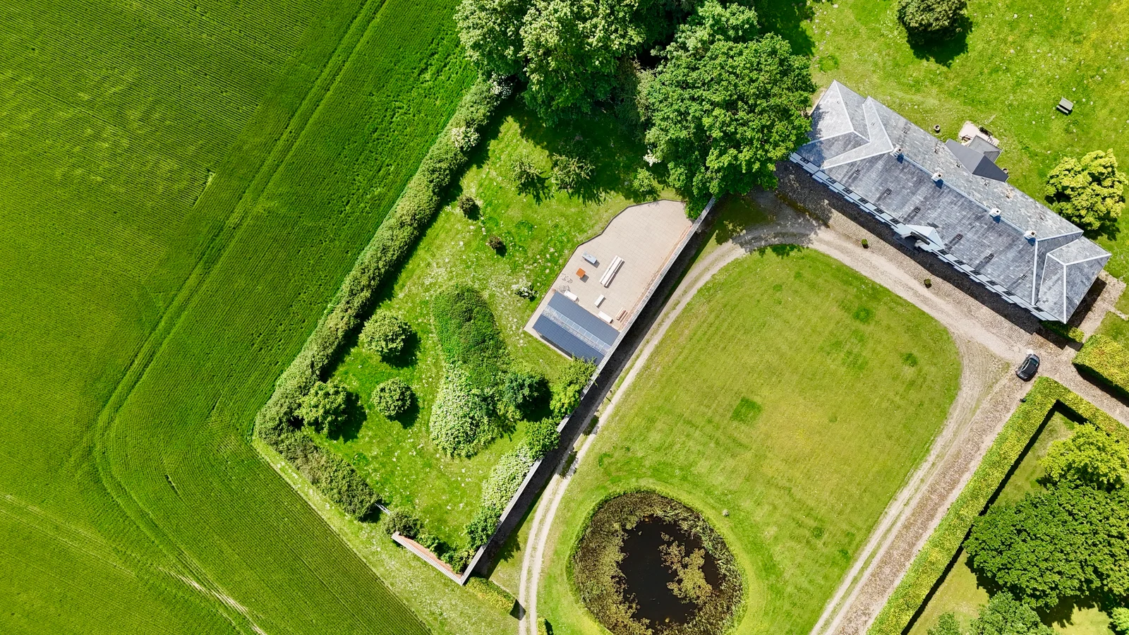 Gut Agerup senkrecht von oben: das Herrenhaus, der Rasen mit dem Teich und der ummauerte Garten