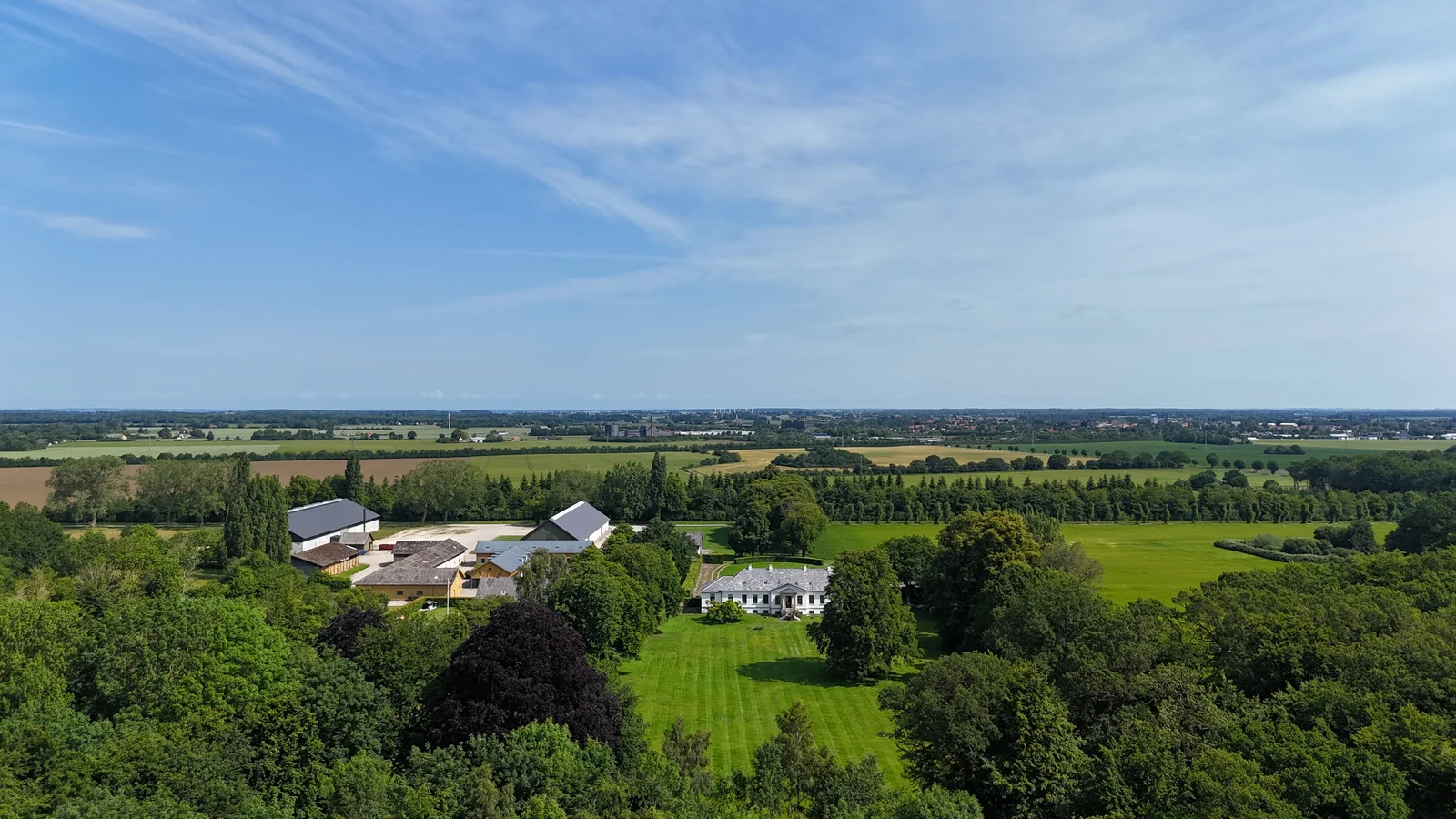 Gut Agerup und die flache Landschaft Lollands aus der Luft an einem klaren Sommertag
