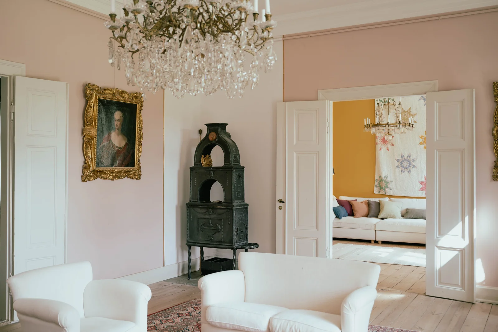 Der Salon von Gut Agerup mit Ahnenporträt, gusseisernem Ofen und Kronleuchter