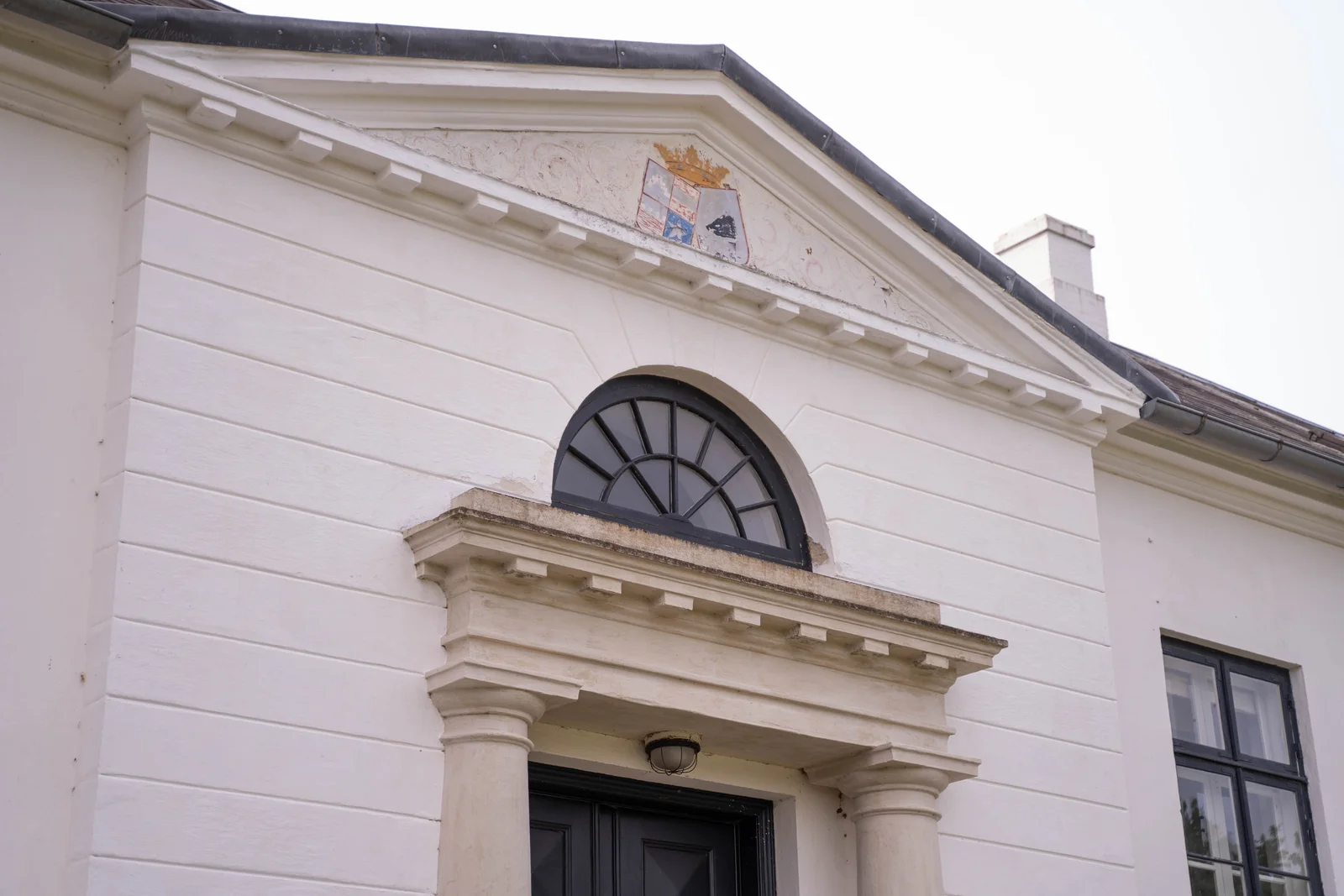 Der Eingangsbereich mit Giebel und Lünettenfenster am Herrenhaus von Gut Agerup
